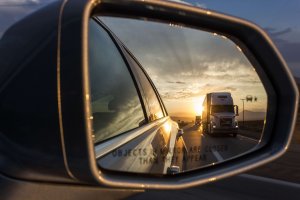 Semi-truck seen in sideview mirror